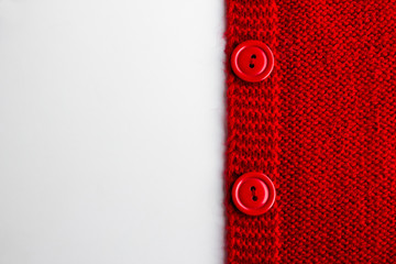 Hand knitted,side of the cardigan on the white surface with large copy space.