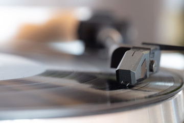 Close up of turntable needle on a vinyl record. Turntable playing vinyl. Needle on rotating black vinyl.