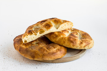 Two and a half Ramadan Bread (Pide) on the round wooden tray.Ramadan concept.
