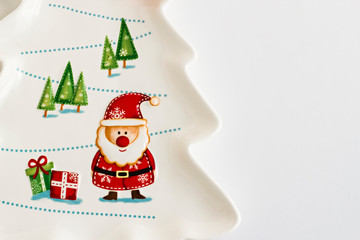 Porcelain plate in the shape of Christmas tree with Christmas pattern on white with copy space,top view