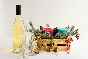 Blue and red color candles in mini wooden box with snowy pine cones,christmas decorations and leaves on white background with campagne bottle.Christmas or New Year concept.