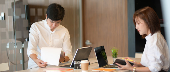 Cropped shot of two businesspeople focusing on their work with computer laptop