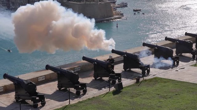 Soldier fire canon facing sea harbor with lot of smoke on sunny day