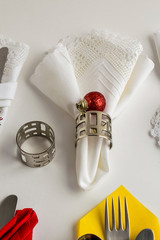 Handmade lace fabric white color napkin on white surface with metal napkin rings and christmas decoration.
