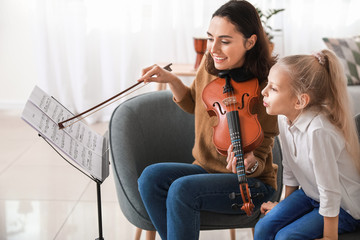 Private music teacher giving violin lessons to little girl at home © Pixel-Shot