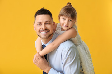 Happy father and his little daughter on color background