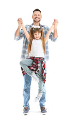 Obraz premium Father and his little daughter dancing against white background