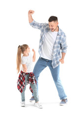 Fototapeta premium Father and his little daughter dancing against white background