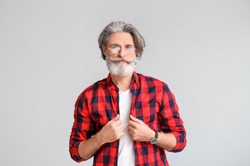 Stylish elderly man on grey background