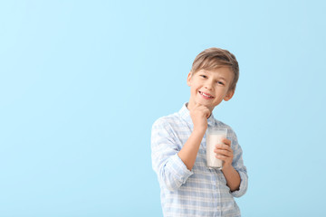 Little boy with milk on color background