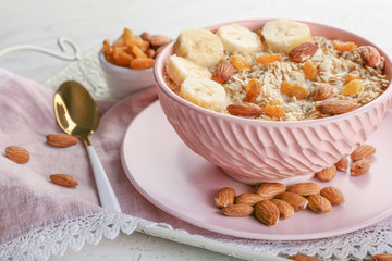 Bowl with tasty sweet oatmeal on tray