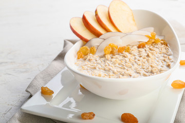 Bowl with tasty sweet oatmeal on white background