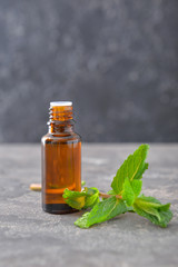 Bottle of mint essential oil on table