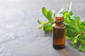 Bottle of mint essential oil on table