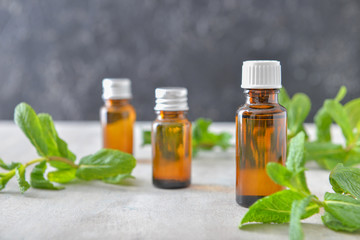 Bottles of mint essential oil on table