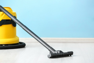 Modern vacuum cleaner near color wall