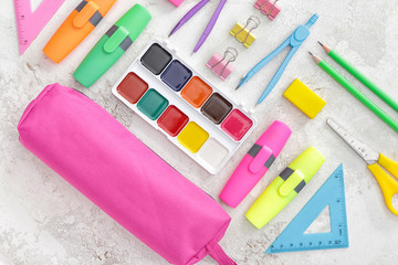 Pencil case and school stationery on light background