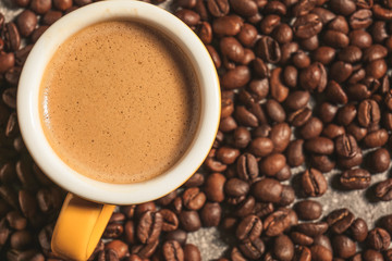 Cup of hot coffee on beans