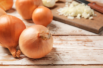 Fresh raw onion on wooden table