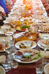 A blurred dining room for an Asian audience sits in a long line of table.