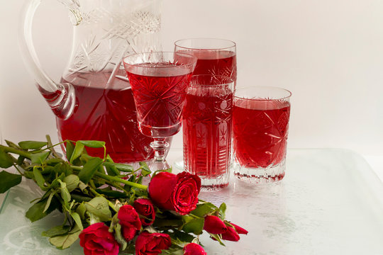 Traditional Turkish Red Rose syrup in different kinds of traditional glasses and jars Ottoman cuisine stylized with fresh bouquet