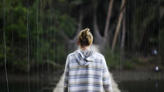 Close up shot of a girl walking on the hanging bridge moody light, Java Indonesia