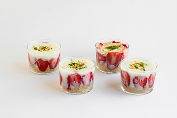 Magnolia puding dessert in transparent glass bowls on the white surface.