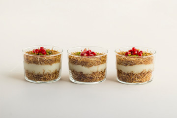 Traditional,milky,crispy Ramadan dessert custard pudding made with roasted kadayif,pomegranate...