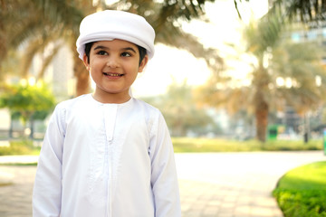 Portrait of young boy wearing Kandura for kids. Handsome Emirati child 