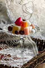 Traditional Turkish candy and delights on glass candy bowl in the wooden tray with handmade lace cloth.The Sugar Feast.