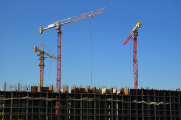 Tower cranes are working on the construction of a new house. Lifting crane.