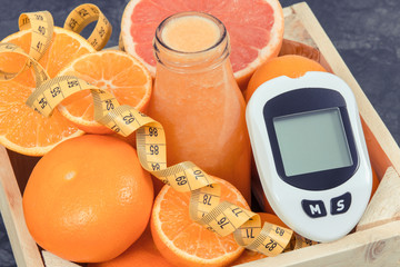 Glucometer, freshly blended coctail or smoothie made of citrus and centimeter. Diabetes, healthy...