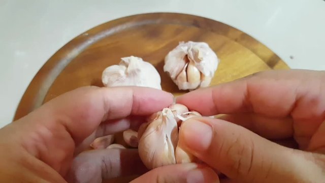 hands peeing fresh garlic