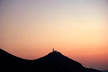 sunset over the mountains and a lighthouse