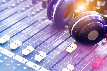 Obraz na płótnie Canvas Professional sound blue headphones on a broadcast audio mixer.