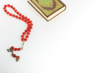 The Islamic holy book, Quran or Kuran, with rosary beads or “tasbih” isolated on white background
