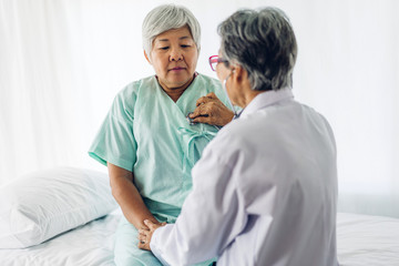 Fototapeta premium Female senior doctor consulting and examining senior woman patient with stethoscope in hospital.healthcare and medicine