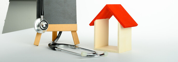 Concept of family medicine - Red Mini house and stethoscope isolated on white background