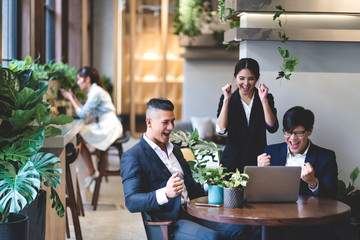 Successful of happy group professional casual business people smiling and laughing to win of celebrating project success.Creative business relaxing and raising hands up in modern office