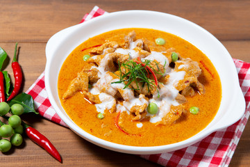 Thai Red curry with pork on wooden background