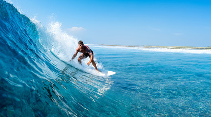 Young man surfs ocean wave in Maldives - obrazy, fototapety, plakaty