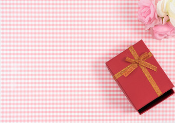 gift box with red isolated on Plaid background. Holiday decoration for Mother's Day or Women's Day.