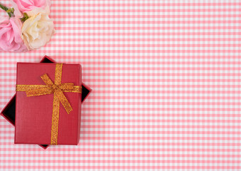 gift box with red isolated on Plaid background. Holiday decoration for Mother's Day or Women's Day.
