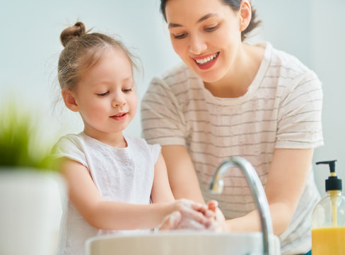 girl and her mother are washing hands