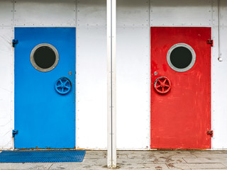 colorful blue and bright red painted door with porthole. metallic entrance doors with round windows