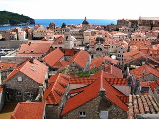 Fototapeta na wymiar view of the old city of Dubrovnik on a clear summer day, you can see many houses with red roofs, the old Cathedral and the sea
