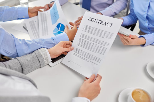 corporate and people concept - close up of business team with charts and contract at office