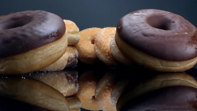 sweet big chocolate donuts are stacked next to each other