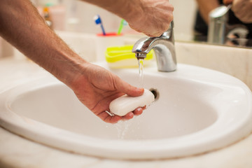 Man washing hands with soap in bathroom. People and healthcare concept.