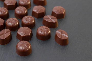 chocolate candies on a black background. dark photo, mood.